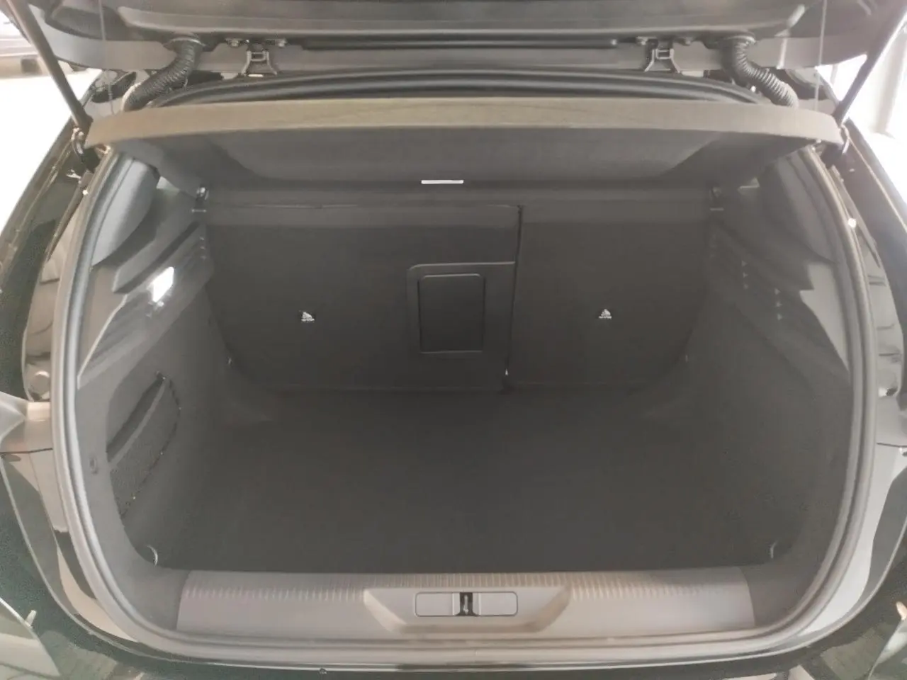 Coffre ouvert de la Peugeot 308 noir métal, vue arrière montrant un espace de chargement spacieux et bien fini.