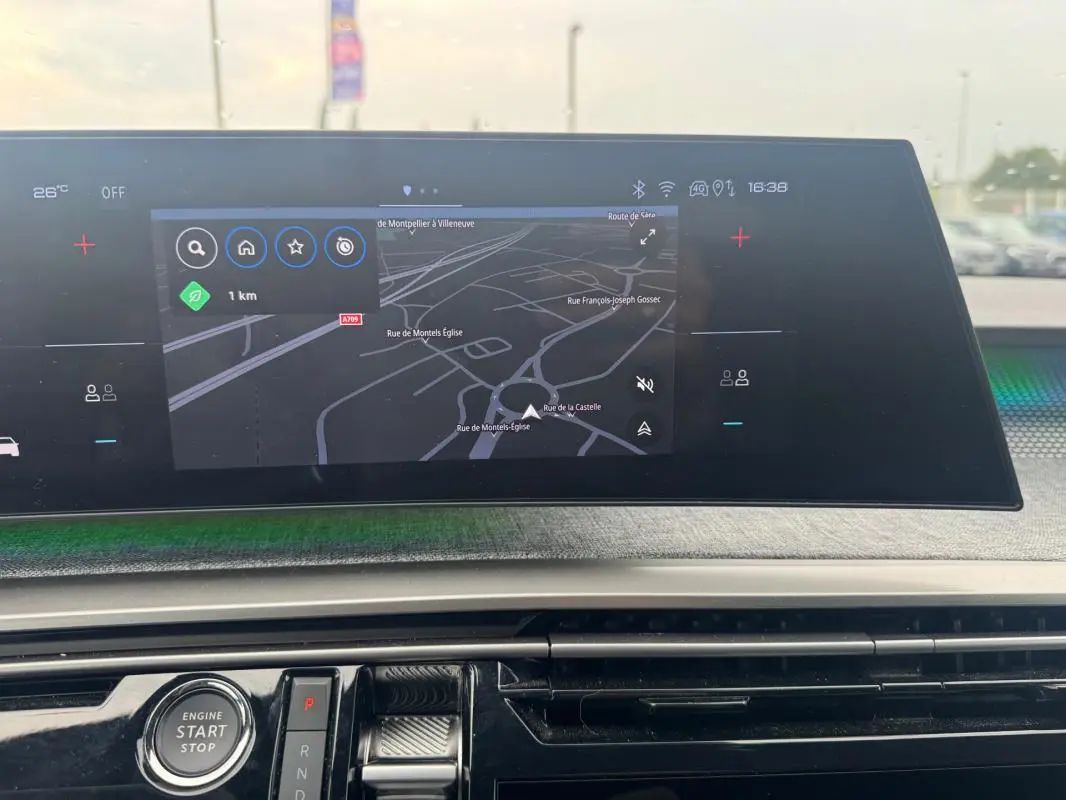 Vue rapprochée du cockpit numérique du Peugeot 5008 Hybrid 145 ch GT 2025, affichant la navigation et le bouton start/stop.