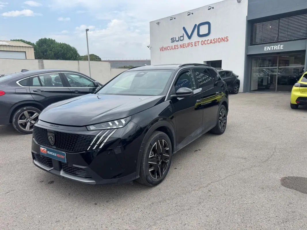 Peugeot 5008 Hybrid noir vue 3/4 avant droit, jantes alliage 19 pouces, barres de toit et calandre distinctive.