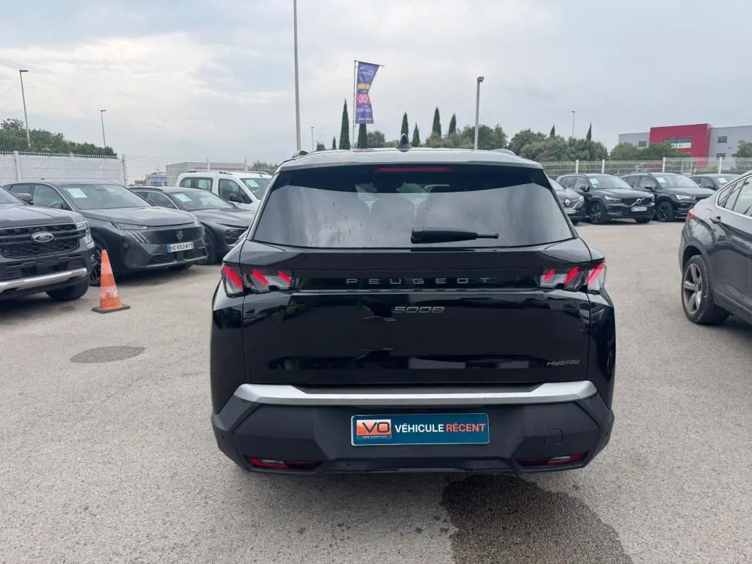 Vue arrière d'un Peugeot 5008 Hybrid noir 2025 avec feux arrière à griffes et plaque "Véhicule récent".