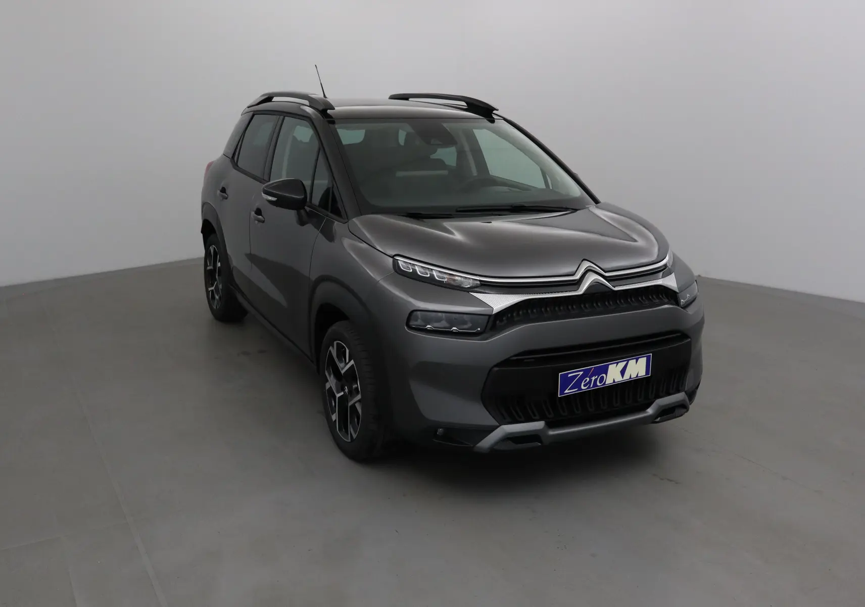 Citroën C3 Aircross gris platinium et noir, vue 3/4 avant droit, avec toit noir et jantes stylées.