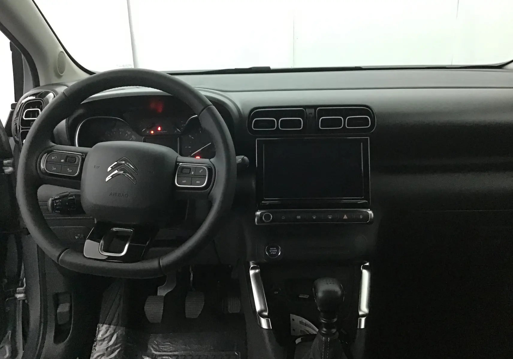 Vue intérieure du tableau de bord et volant du Citroën C3 Aircross 2024, avec écran tactile et commandes au volant.