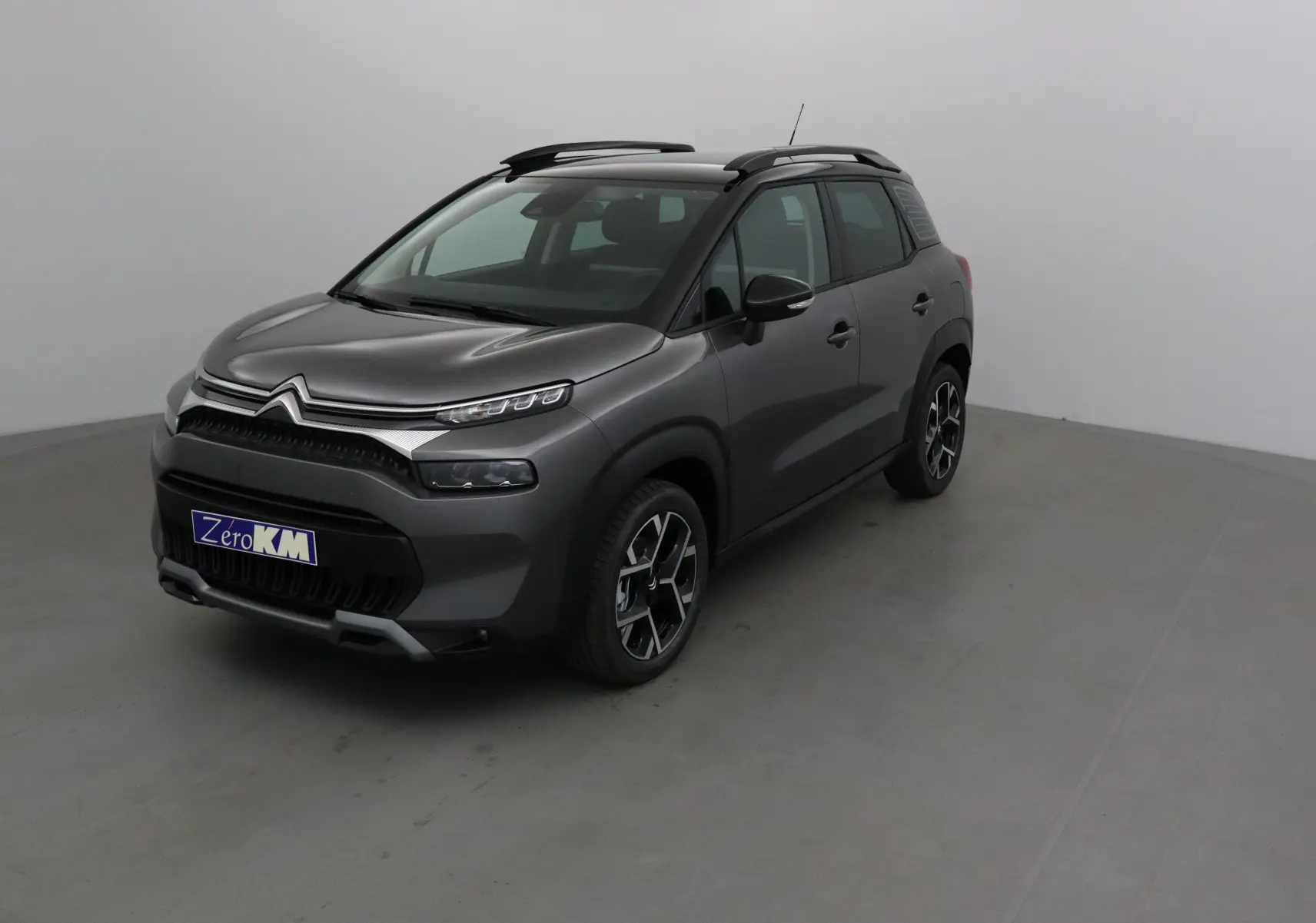 Citroën C3 Aircross 2024 gris platinium et noir en 3/4 avant droit avec jantes alliage et toit noir.