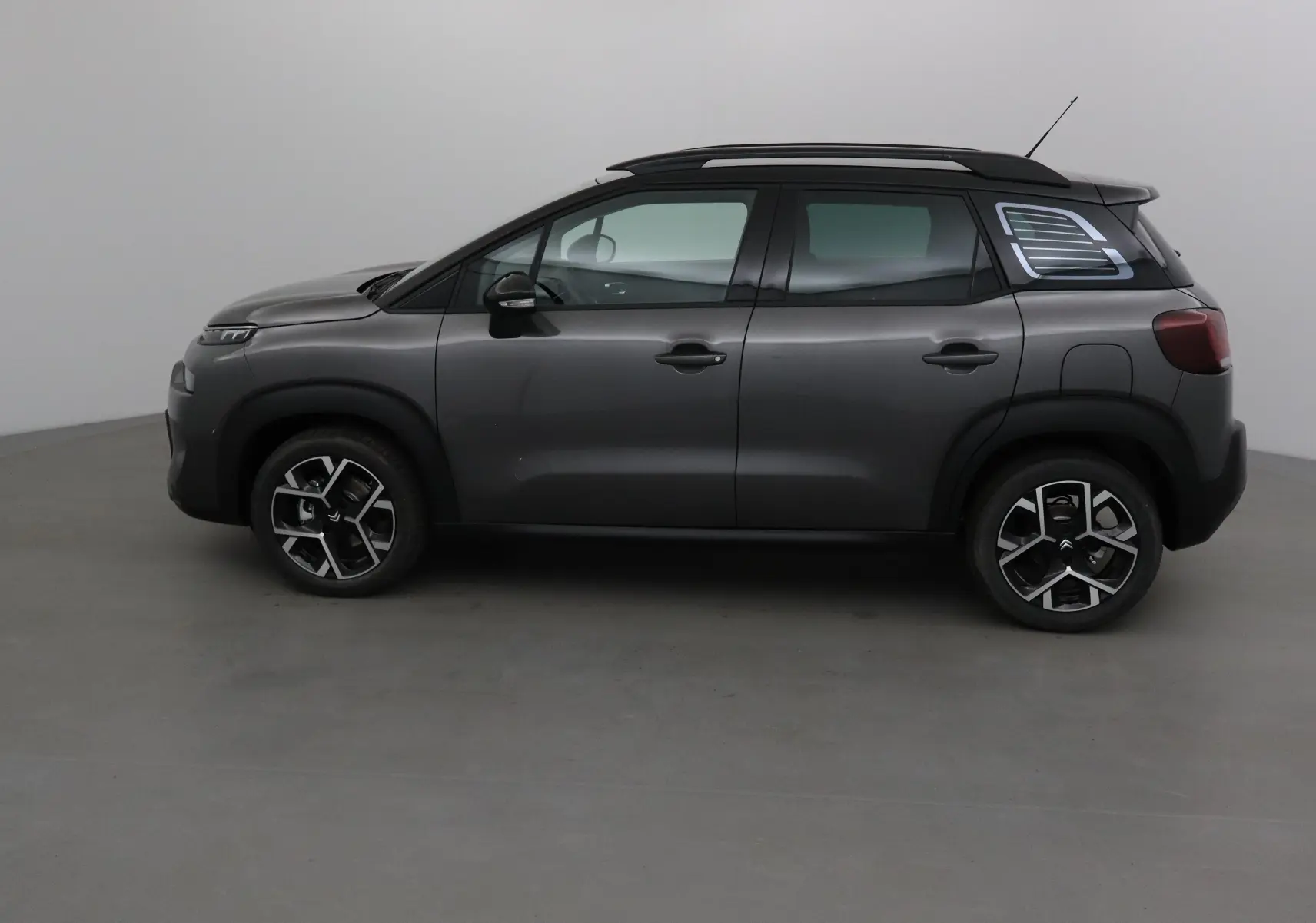 Profil côté gauche d'un Citroën C3 Aircross gris platinium avec toit noir et jantes alliage 17 pouces.