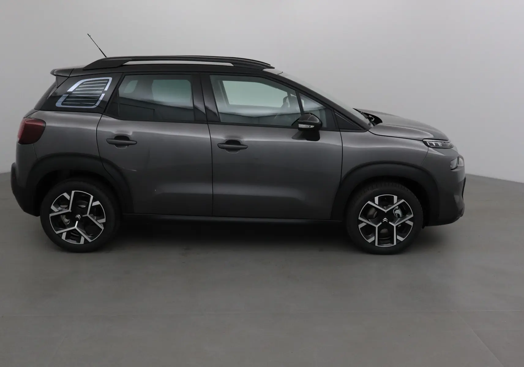Profil côté gauche du Citroën C3 Aircross gris platinium avec toit noir et jantes alliage 17 pouces.