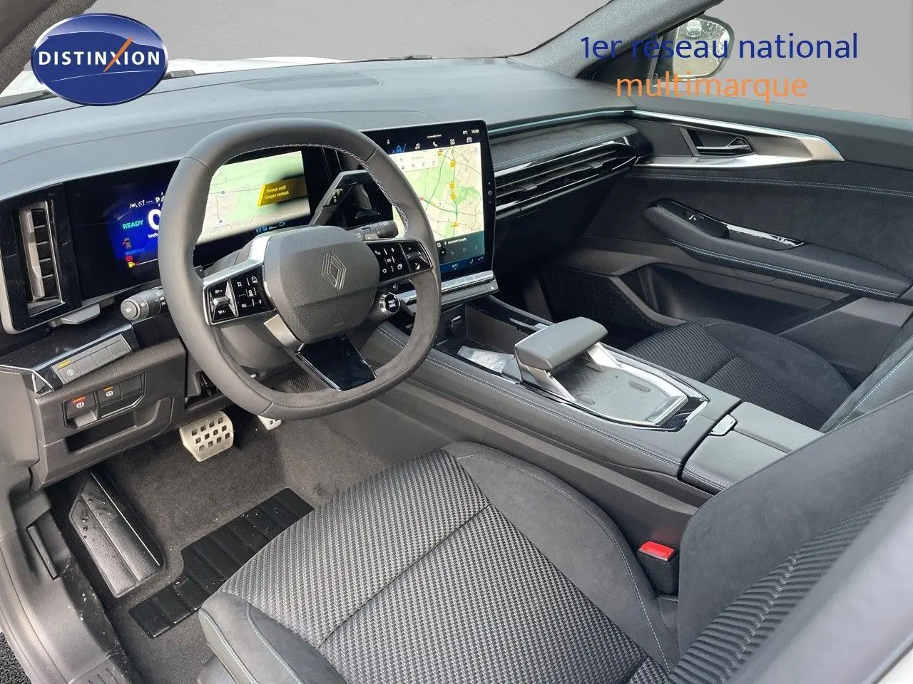 Intérieur avant droit du Renault Austral 2025 hybride, avec tableau de bord numérique et écran tactile central moderne.