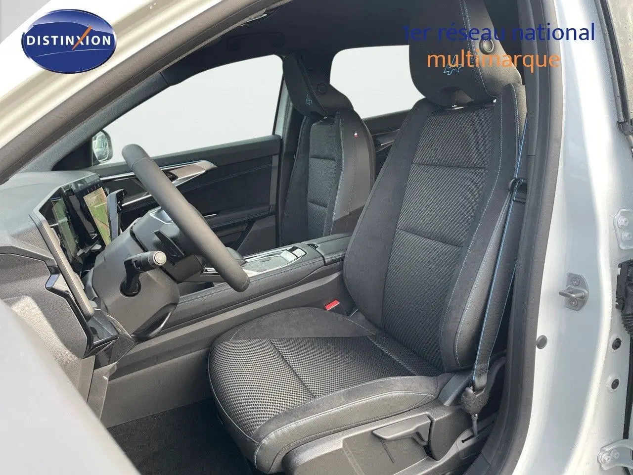 Intérieur du Renault Austral E-Tech hybride 2025, vue côté conducteur, sièges noirs en cuir et alcantara avec surpiqûres bleues.