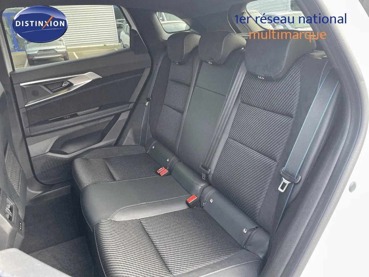 Vue côté gauche des sièges arrière noirs en tissu et cuir du Renault Austral blanc nacré 2025, avec surpiqûres bleues.