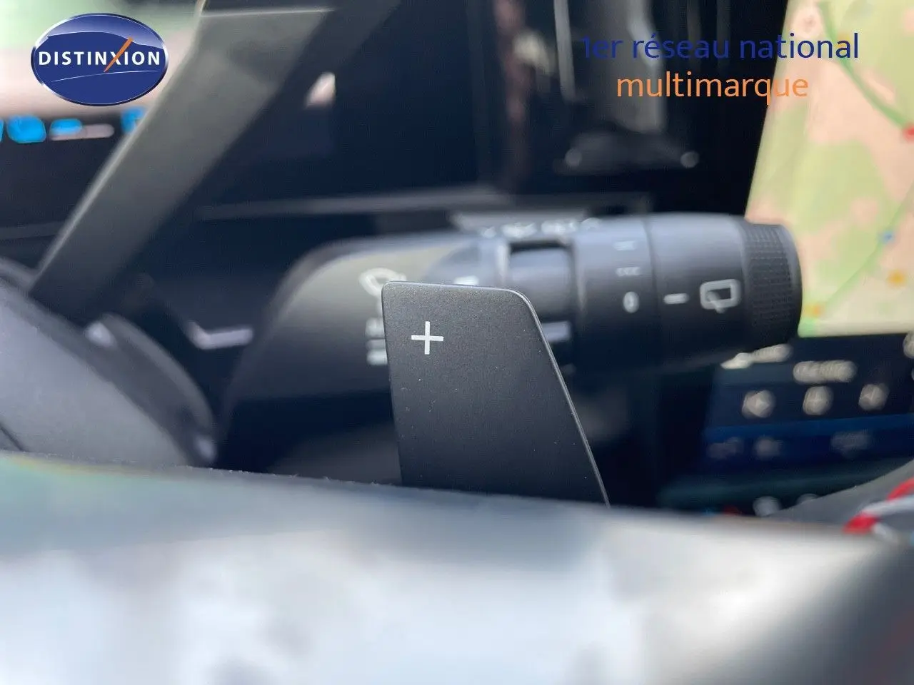 Gros plan sur la palette de changement de vitesse droite dans l'habitacle noir du Renault Austral blanc nacré.