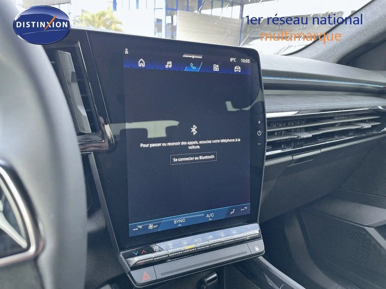 Vue rapprochée de l'écran tactile central du tableau de bord du Renault Austral blanc nacré 2025, affichant la connexion Bluetooth.