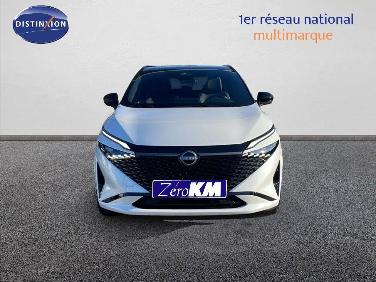 Vue frontale d'un Nissan Qashqai 2025 blanc nacré avec toit noir, mettant en valeur sa calandre noire et ses phares LED fins.