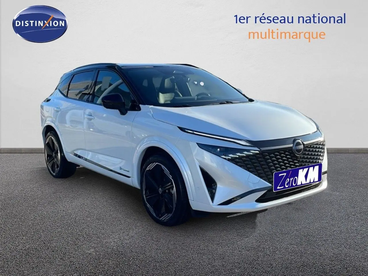 Nissan Qashqai 2025 blanc nacré avec toit noir, vue 3/4 avant mettant en valeur sa calandre distinctive et ses jantes noires.