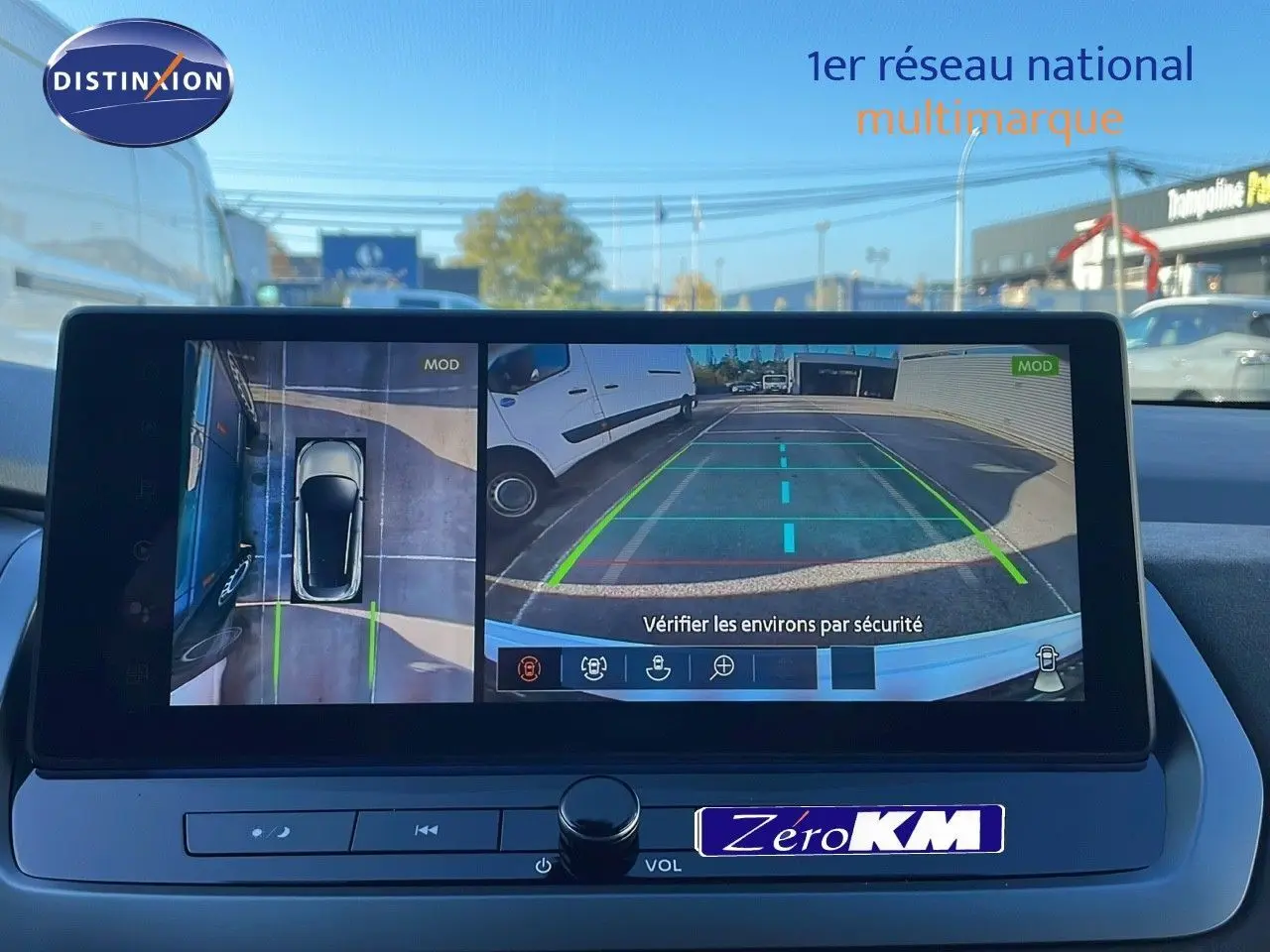 Écran de caméra 360° du Nissan Qashqai 2025 blanc nacré avec toit noir, vue arrière et dessus en parking.