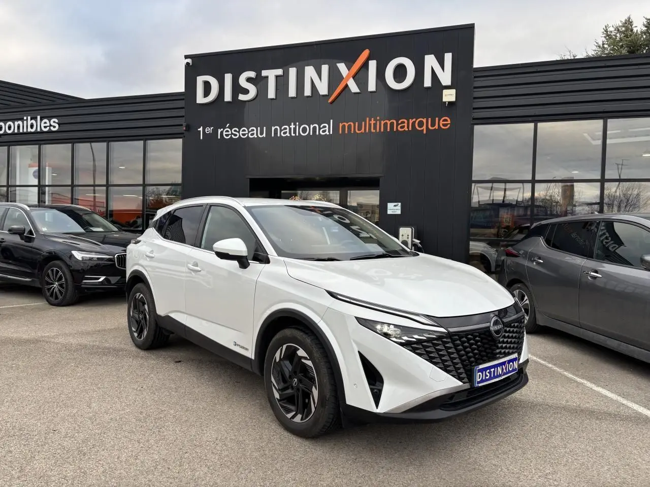 Nissan Qashqai III blanc nacré en 3/4 avant droit, avec calandre noire et jantes alliage noires distinctives.