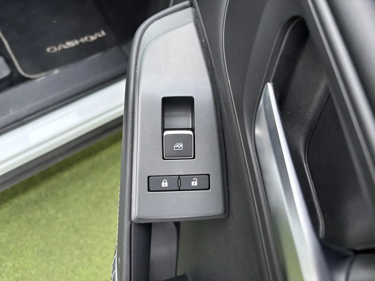 Gros plan sur les commandes de verrouillage et lève-vitre côté conducteur du Nissan Qashqai blanc nacré 2025.