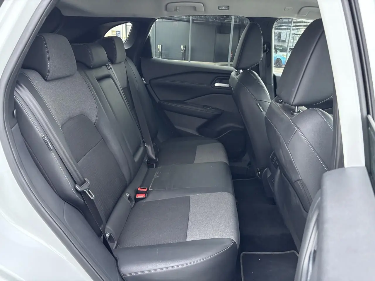 Vue intérieure côté droit montrant la banquette arrière mixte tissu et TEP noire du Nissan Qashqai blanc nacré 2025.