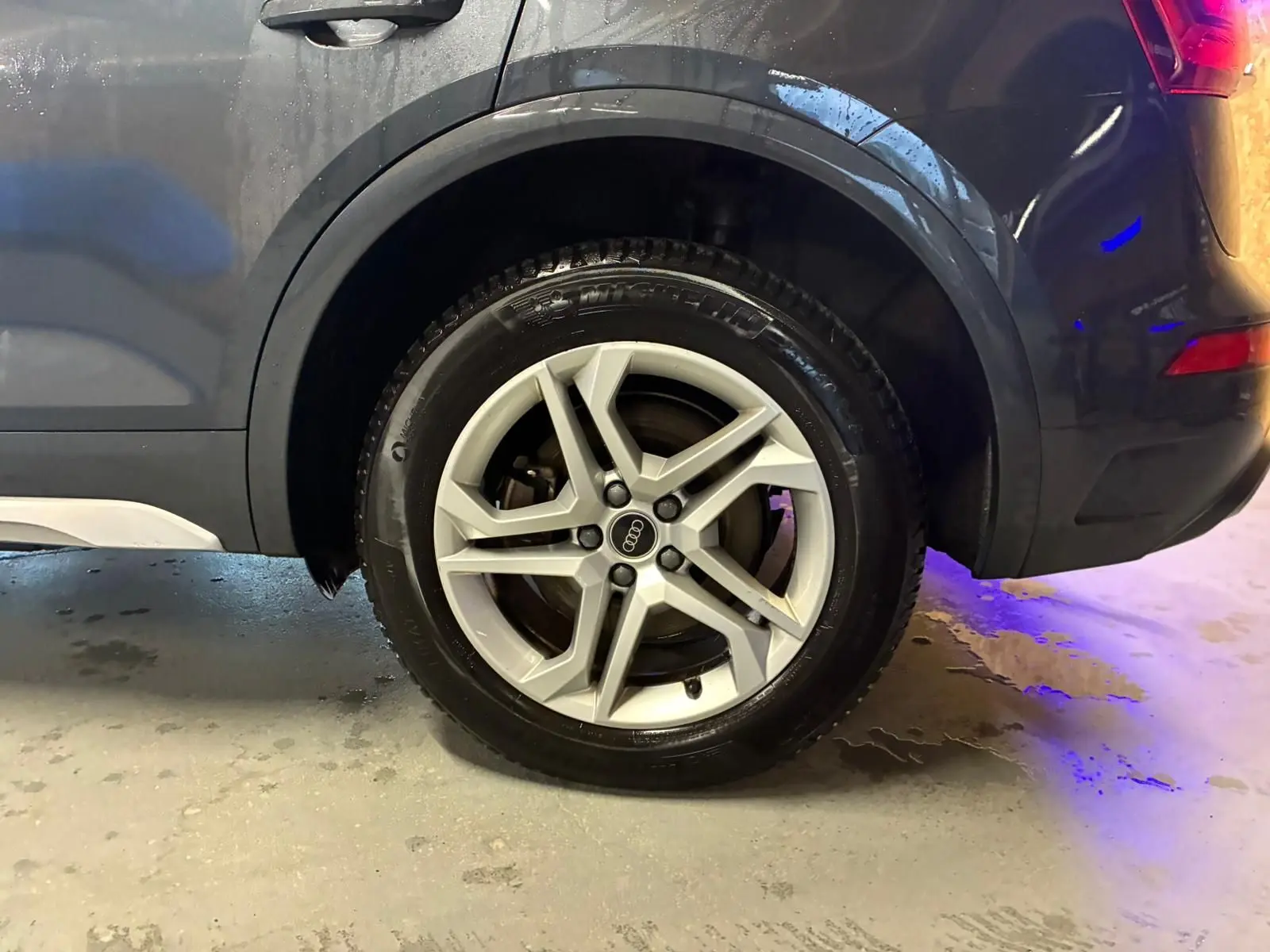 Gros plan sur la roue arrière droite grise d’un Audi Q5 2024 avec jante aluminium à 5 branches doubles.