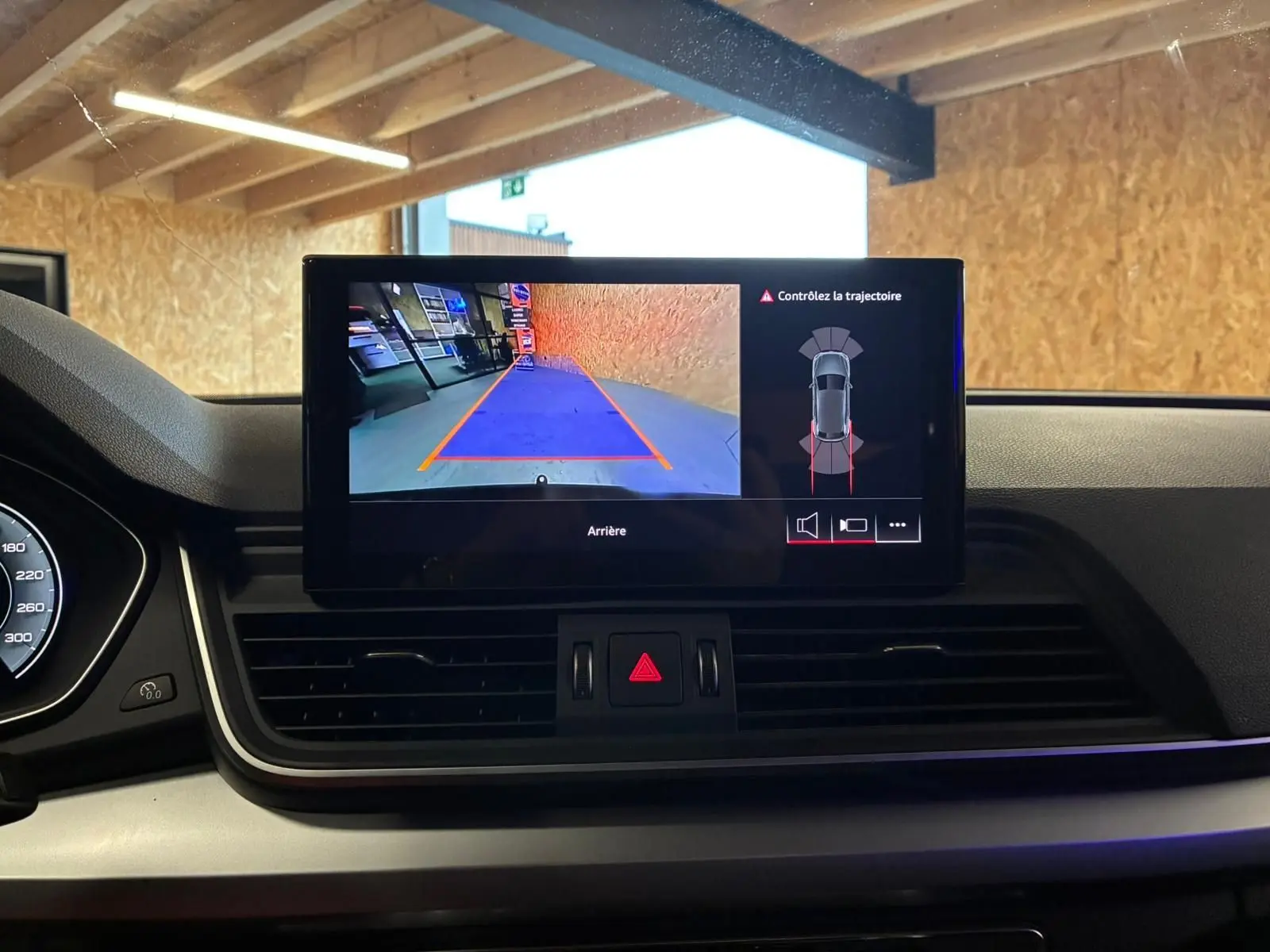 Écran central du tableau de bord d’un Audi Q5 2024 affichant la caméra de recul et l’alerte de trajectoire.