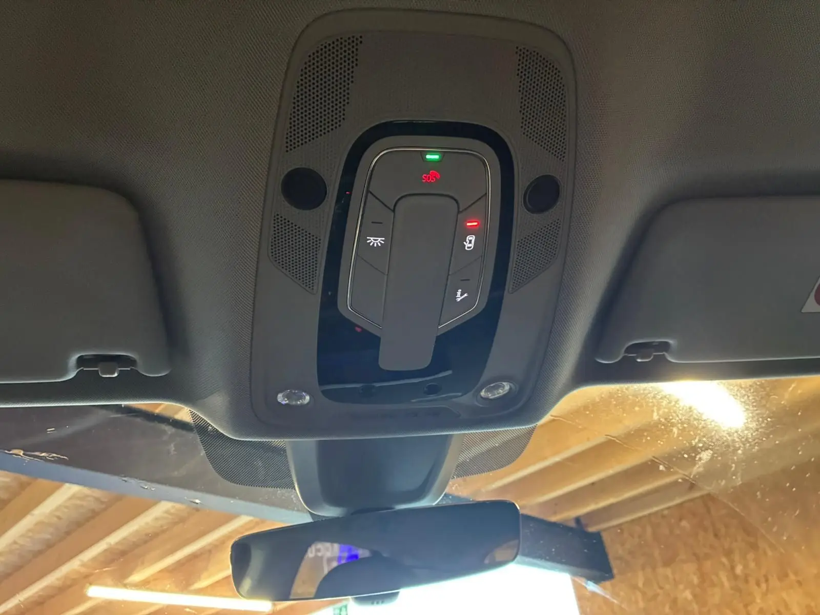 Vue intérieure du plafonnier et du rétroviseur intérieur d'un Audi Q5 2024 gris hybride rechargeable.