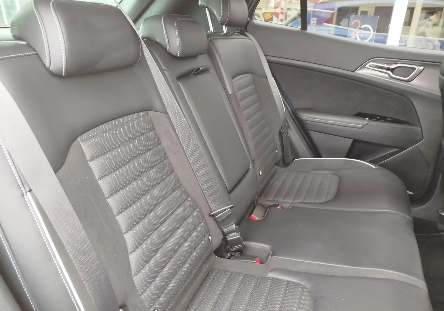 Vue intérieure côté droit des sièges arrière noirs en cuir et tissu du Kia Sportage 2022, finition GT-Line Premium.