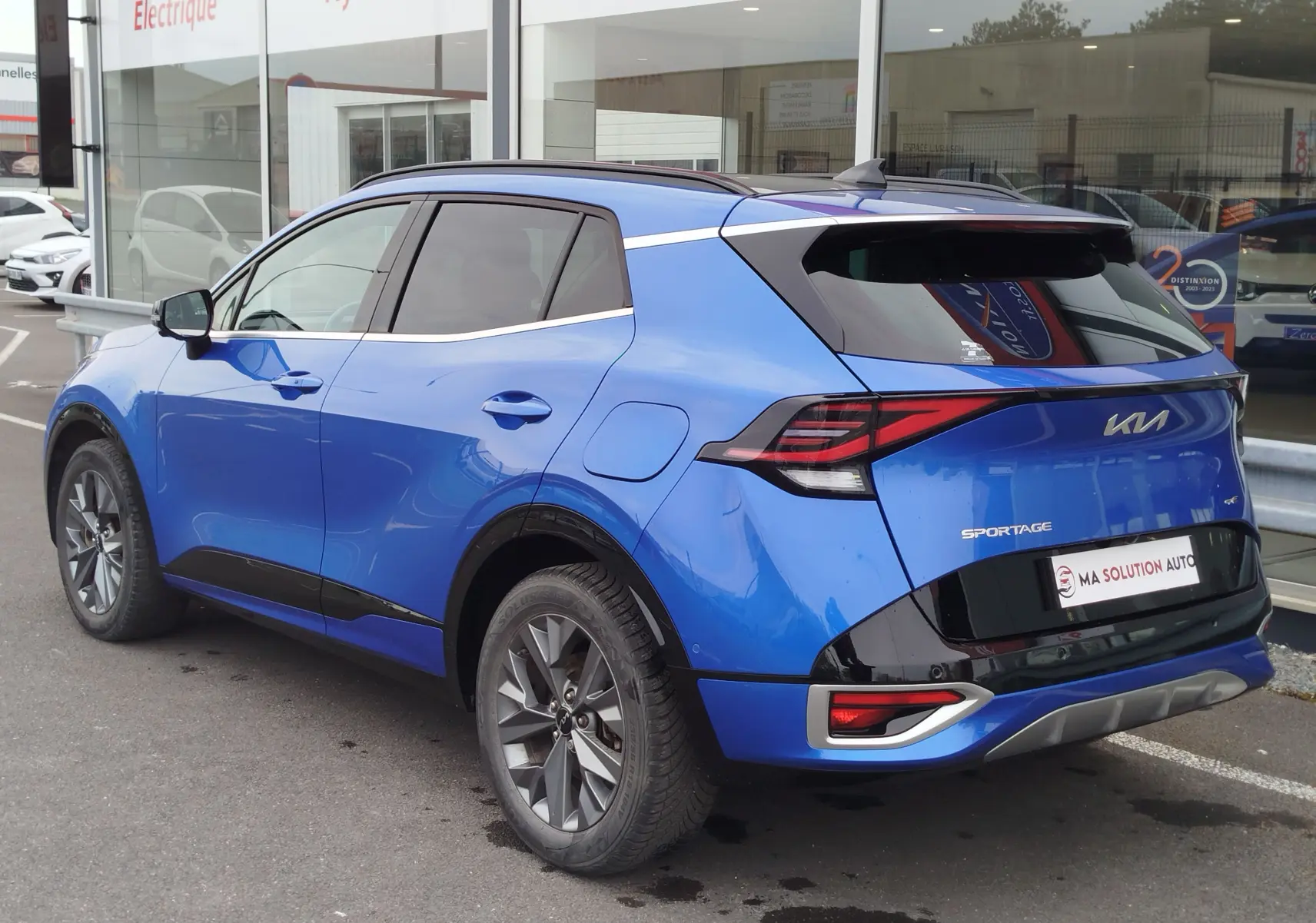 Vue 3/4 arrière droite du Kia Sportage 2022 bleu Fusion métallisé avec feux arrière LED et jantes alliage.