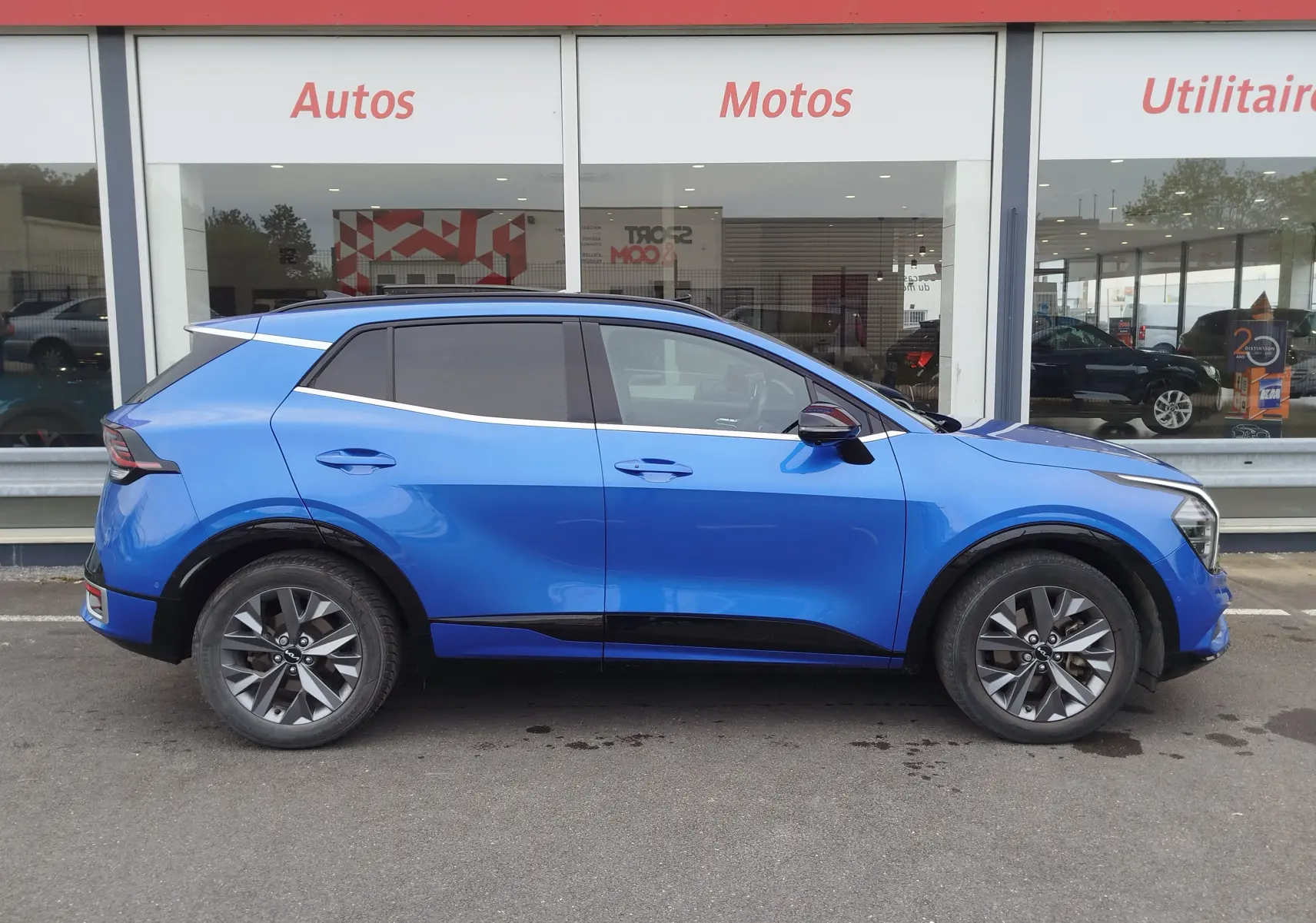 Profil droit du KIA SPORTAGE bleu métallisé, soulignant ses lignes modernes et ses jantes alliage distinctives.