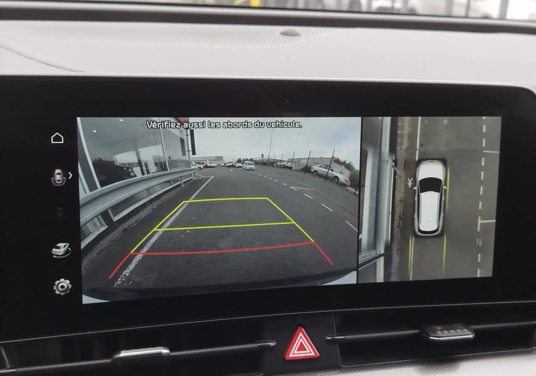 Écran de caméra de recul du Kia Sportage bleu, vue arrière et vue aérienne du véhicule en stationnement.