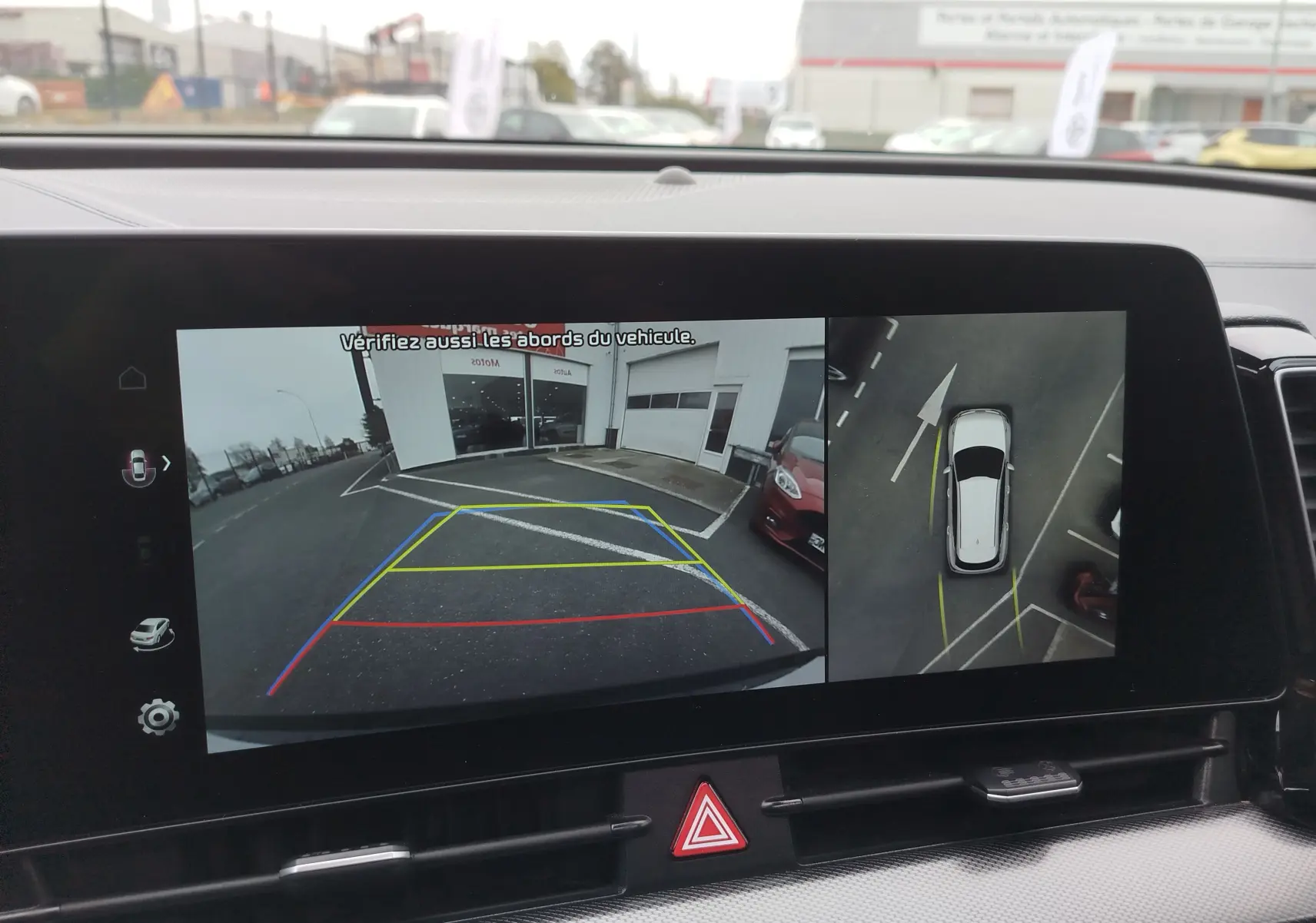 Affichage de la caméra de recul et vue aérienne du Kia Sportage bleu Fusion métallisé en stationnement arrière.