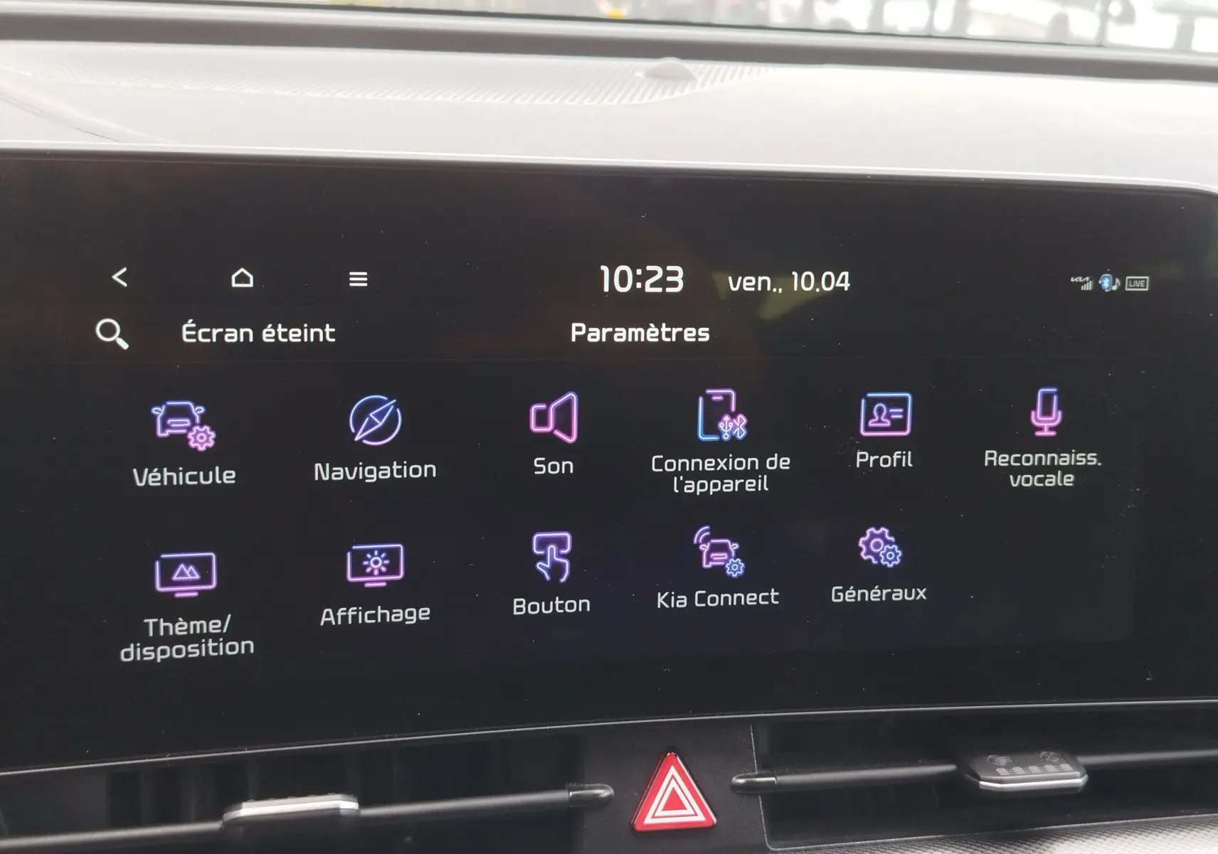 Écran tactile central du Kia Sportage 2022 affichant le menu des paramètres avec icônes colorées sur fond noir.