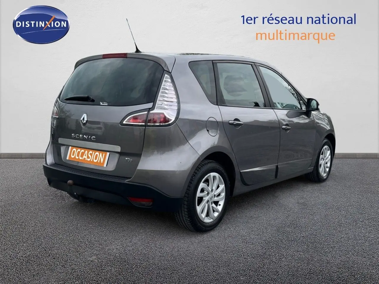 Renault Scénic III gris vue 3/4 arrière droit, avec feux arrière caractéristiques et jantes alliage.