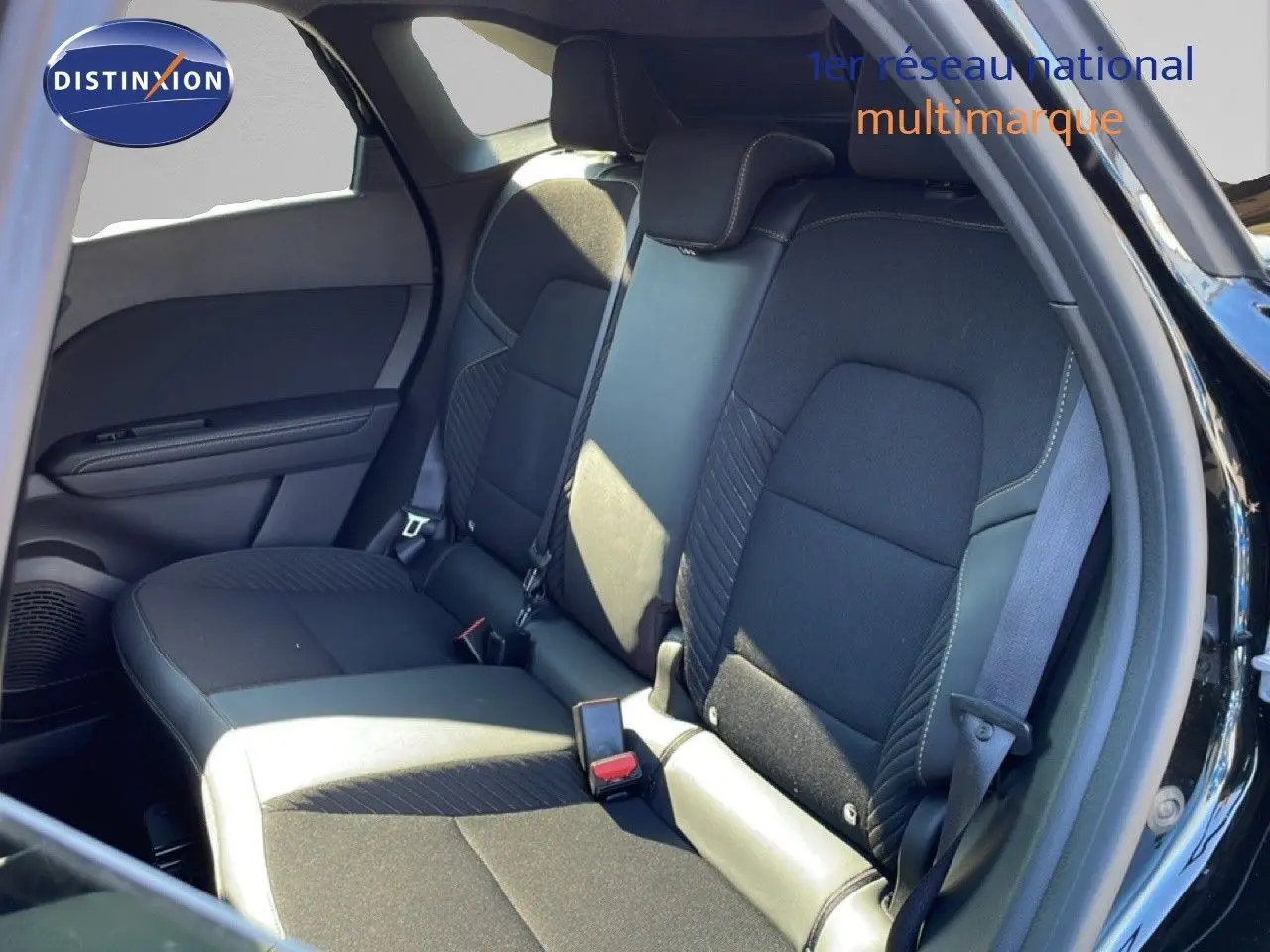 Vue intérieure sur la banquette arrière en tissu noir avec surpiqûres, porte ouverte côté droit du Renault Symbioz noir étoile métal.