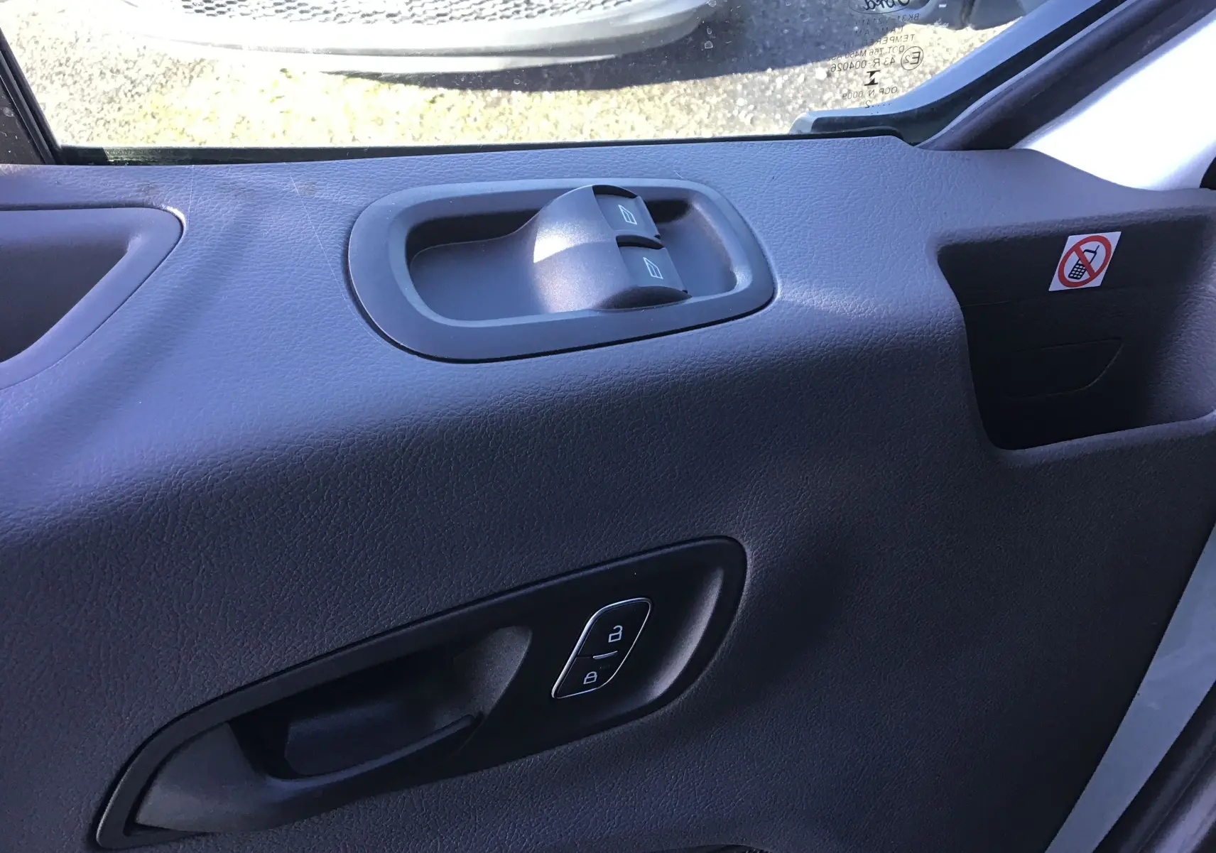 Gros plan sur la porte intérieure côté gauche du Ford Transit Châssis Cabine blanc, avec commandes de vitres et verrouillage.