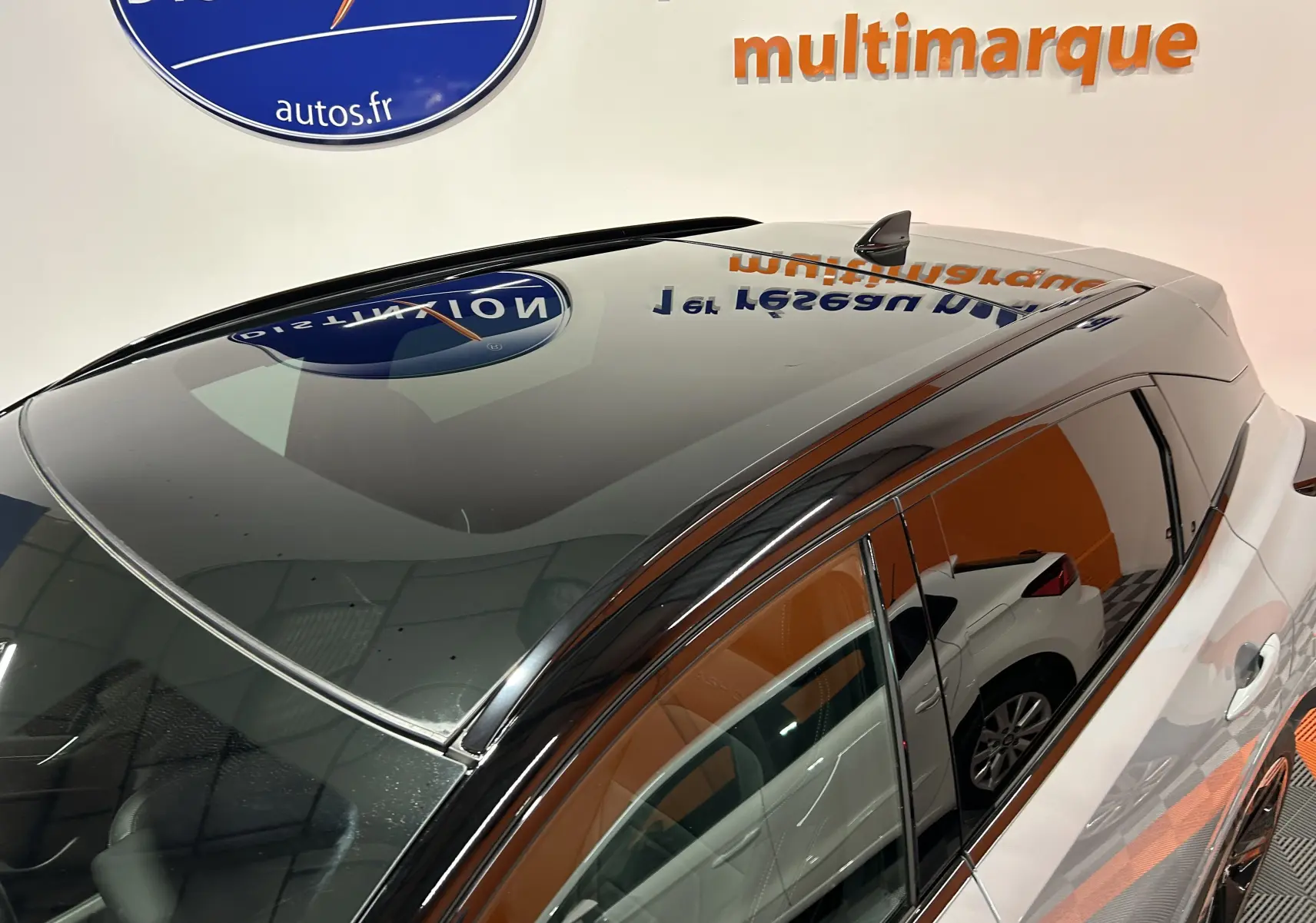 Vue plongeante sur le toit panoramique noir et la carrosserie gris céramique métallisé du Nissan Qashqai 2025 côté gauche.