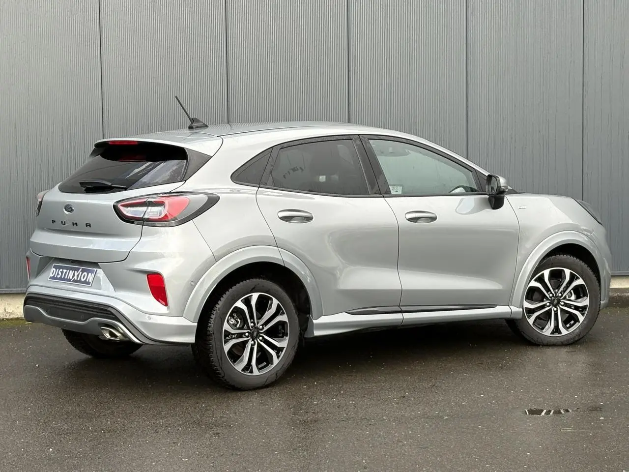 Vue 3/4 arrière droite du Ford Puma gris Solar avec jantes alliage 17 pouces et hayon électrique visible.