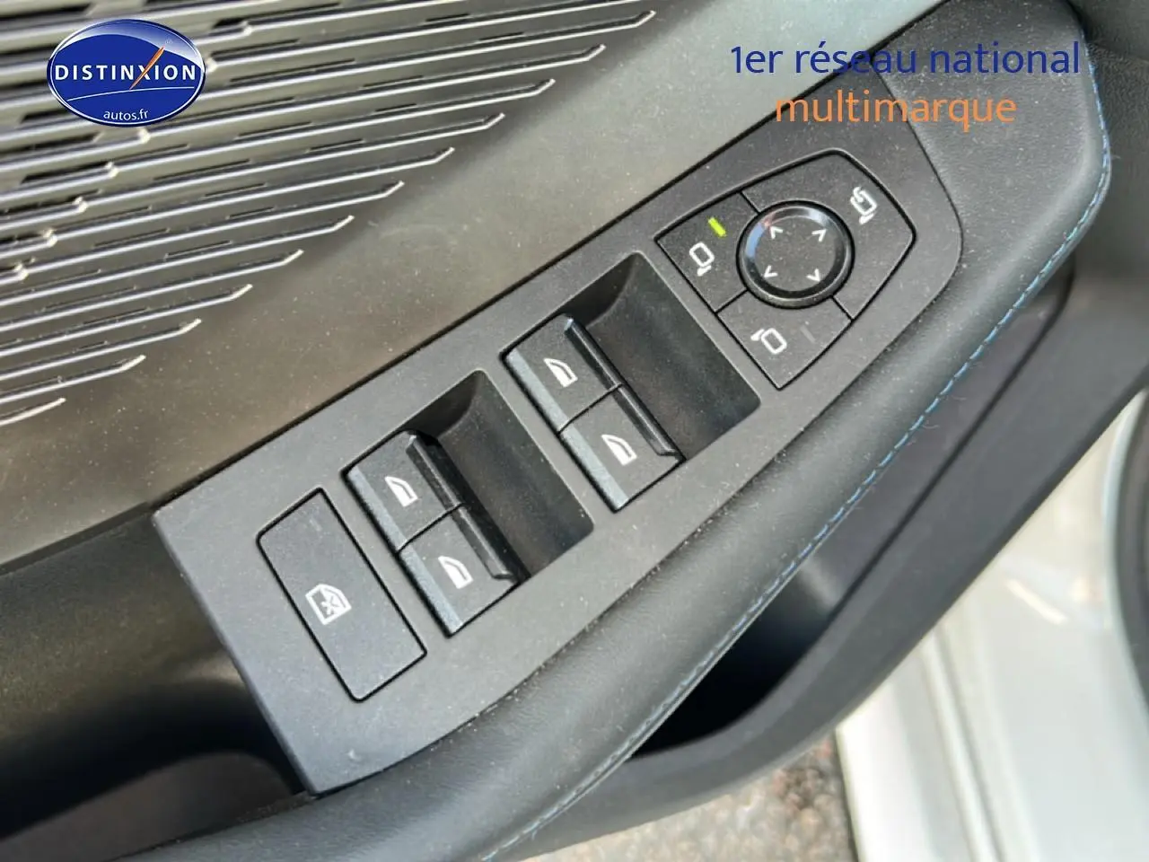 Détail des commandes des vitres et rétroviseurs sur la porte côté conducteur d'une BMW Série 1 blanche.