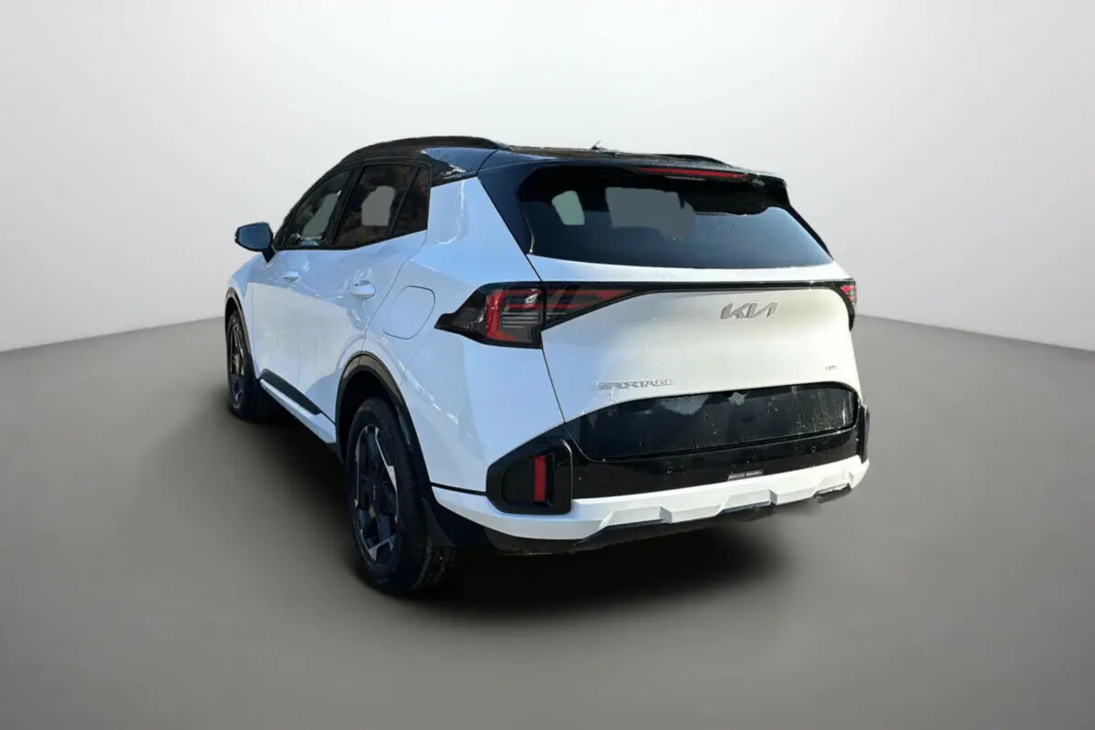Vue 3/4 arrière gauche du Kia Sportage blanc nacré avec toit noir et feux arrière LED distinctifs.