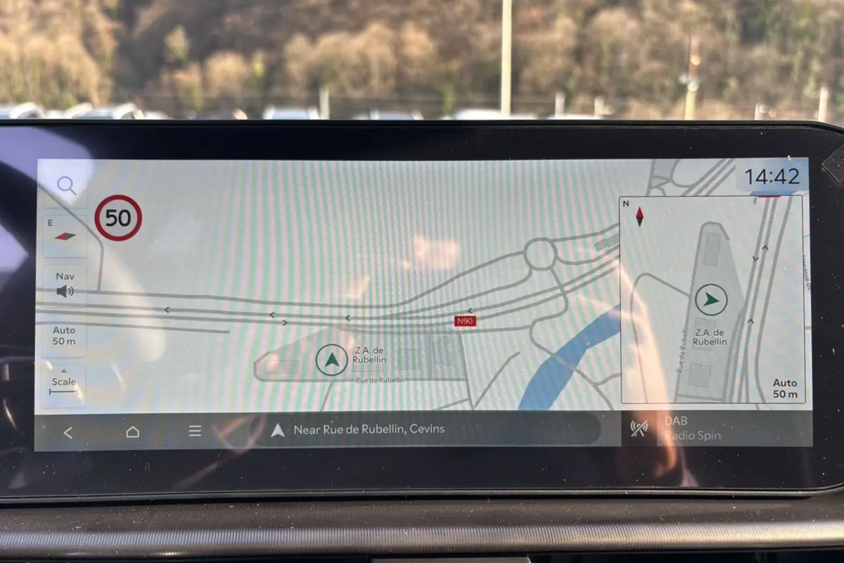 Écran GPS 12,3 pouces du Kia Sportage 2026 affichant une carte avec indication de zone industrielle et limitation à 50 km/h.