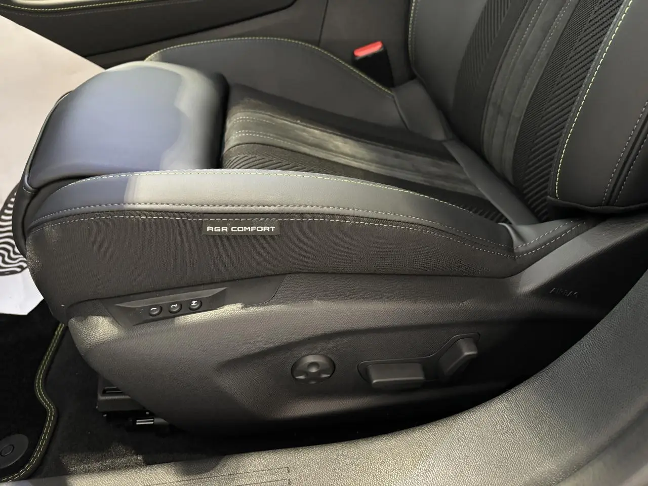 Gros plan sur siège conducteur noir Alcantara avec surpiqûres vert Adamite dans Peugeot 308 gris Selenium.