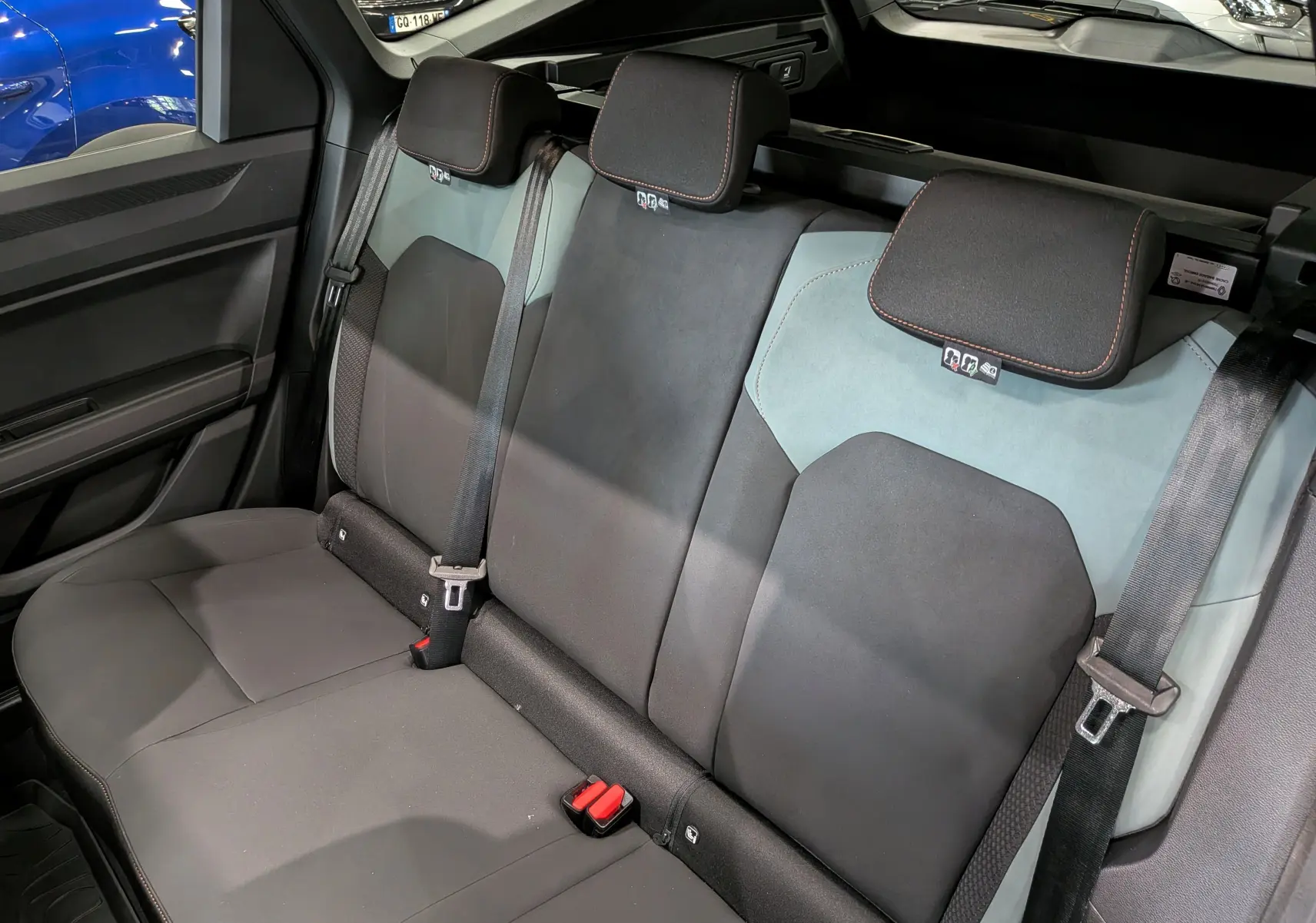 Vue intérieure de la banquette arrière du Dacia Bigster Hybrid-G 150 4x4, sièges bi-matière noirs et verts cèdre.