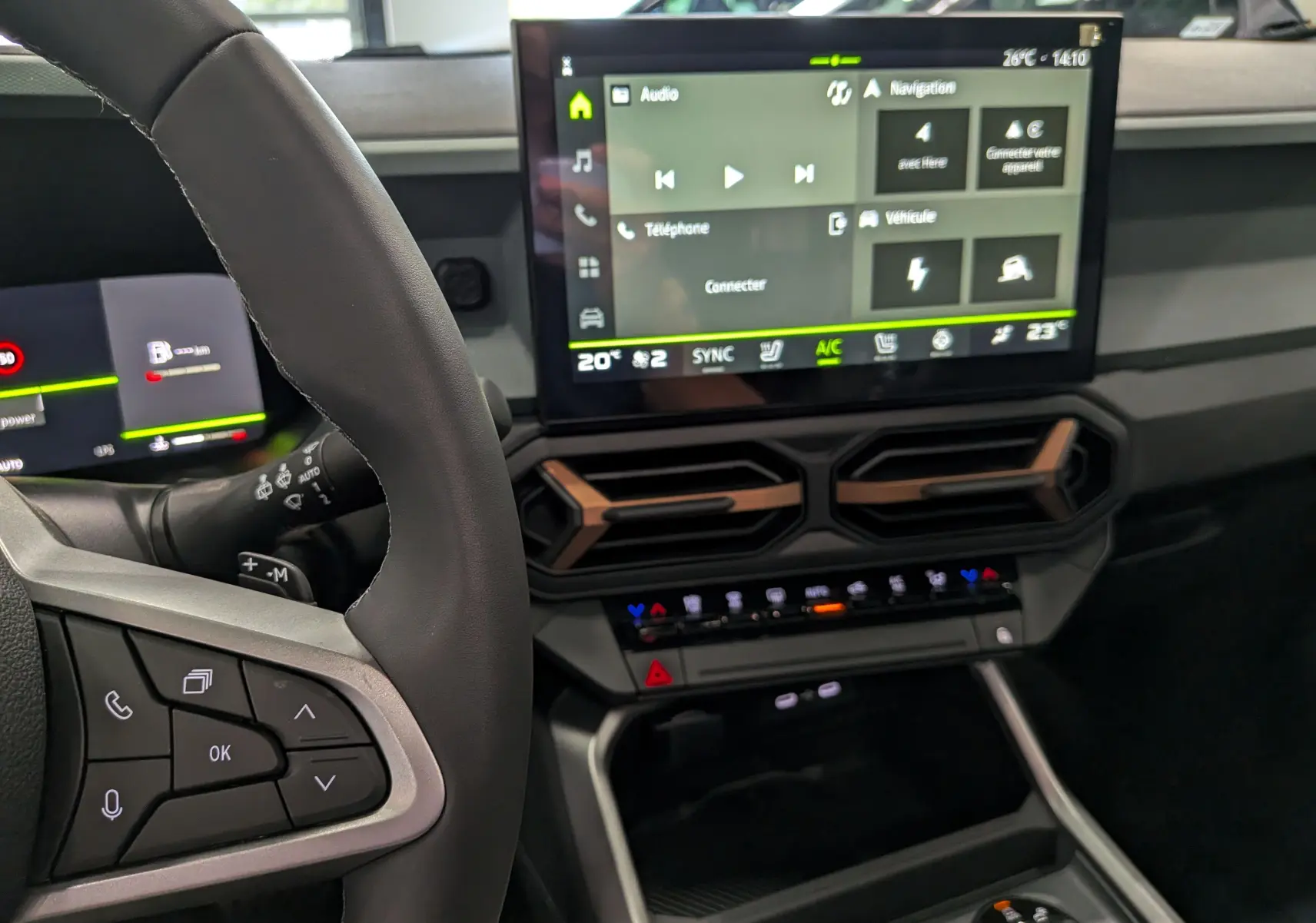 Vue intérieure centrée sur le tableau de bord et l'écran tactile du Dacia Bigster Hybrid-G 150, avec commandes au volant visibles.