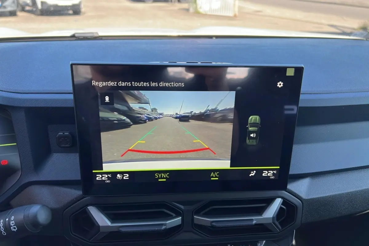 Écran central du tableau de bord du Dacia Bigster 2025 montrant la caméra de recul et la climatisation à 22°C.