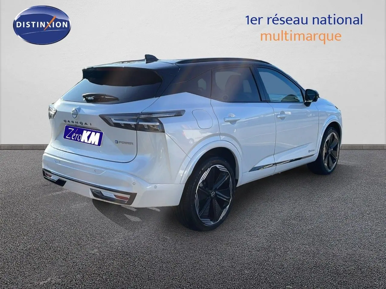 Nissan Qashqai blanc nacré avec toit noir, vue 3/4 arrière droit mettant en valeur ses jantes noires et son design moderne.