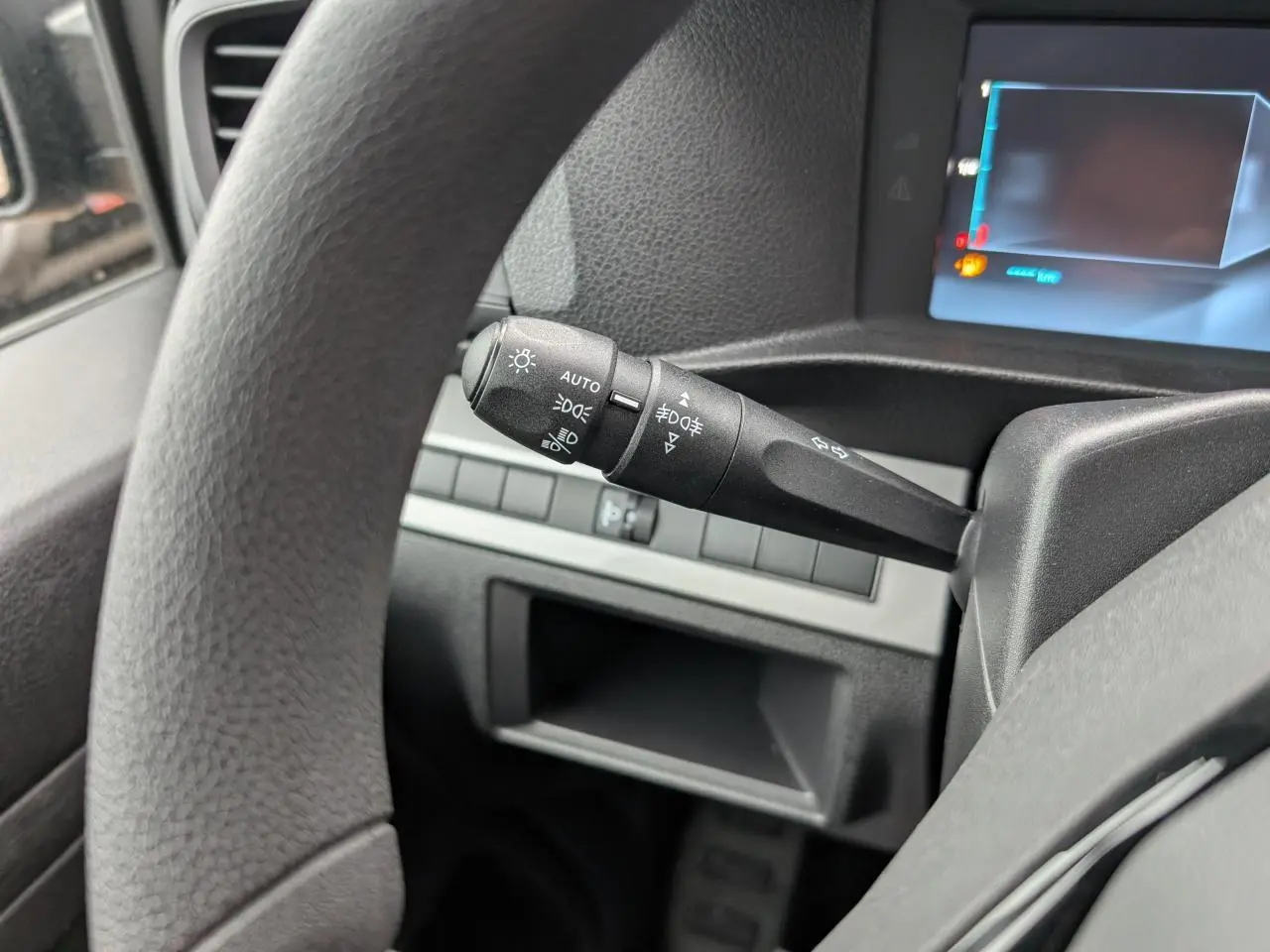Gros plan sur la manette de commande d'éclairage à gauche du volant du Citroën Jumpy gris 2025.
