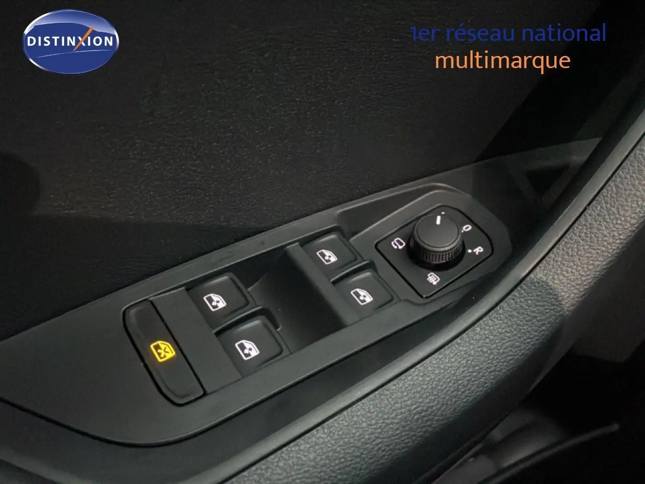 Gros plan sur les commandes de lève-vitres et réglage des rétroviseurs côté conducteur du Skoda Karoq gris argent 2025.