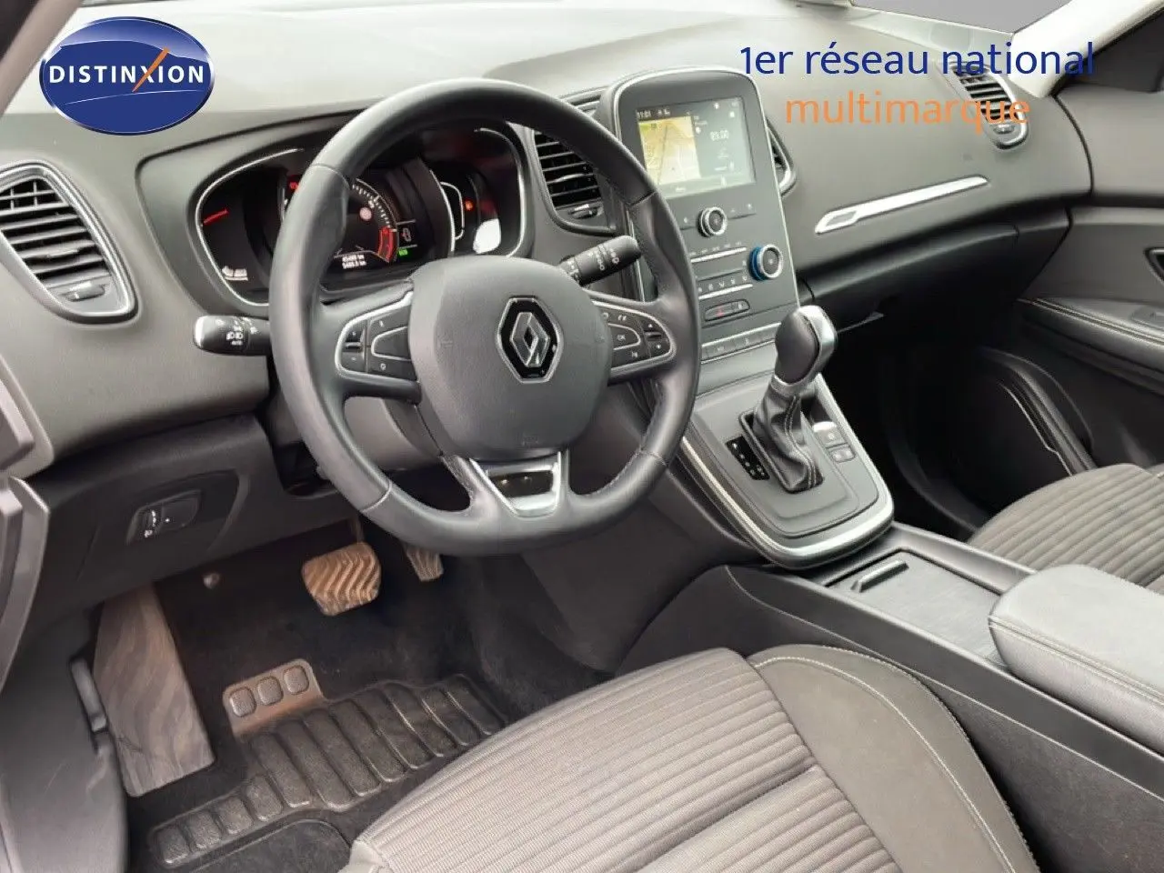 Intérieur Renault Grand Scénic 2022 vu côté conducteur, volant cuir multifonction et console centrale avec écran tactile.