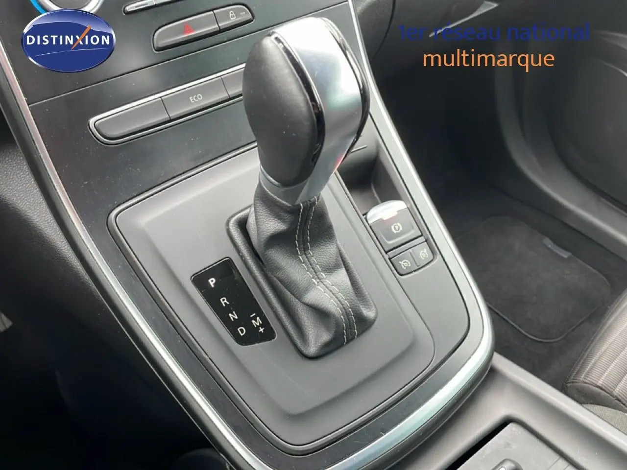 Le levier de boîte automatique noir du Renault Grand Scenic TCE 140CH, vu en gros plan côté conducteur.