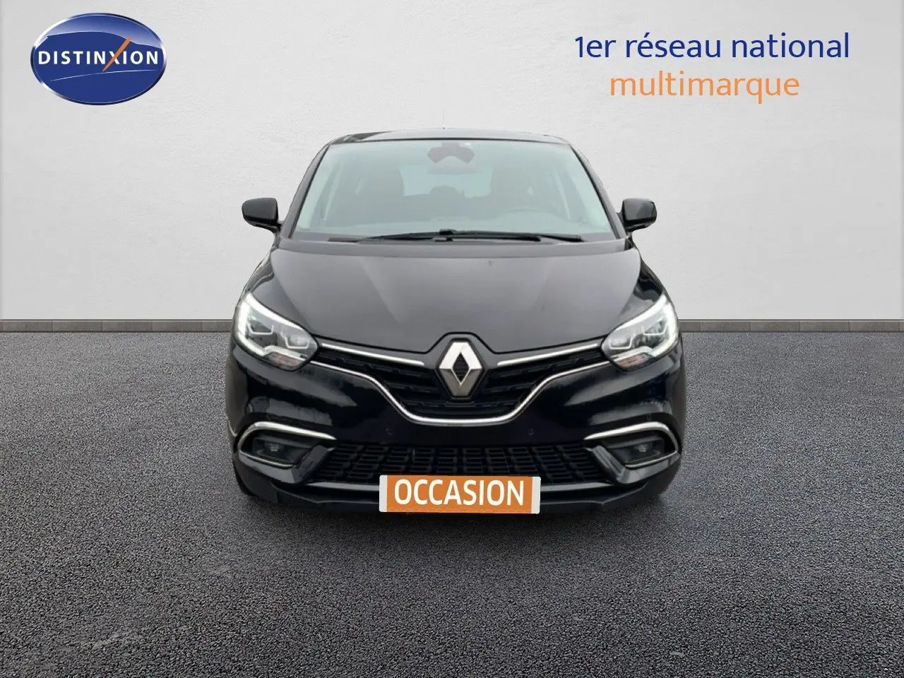 Vue avant d'un Renault Grand Scénic noir étoile métal avec calandre chromée et phares LED allumés.