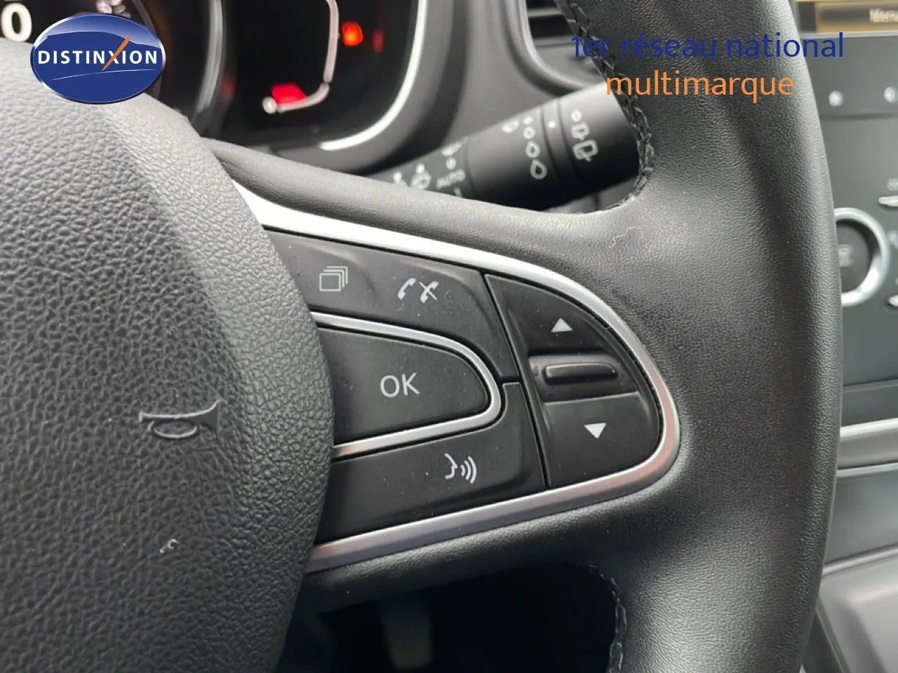 Gros plan sur le volant noir du Renault Grand Scenic 2022, montrant les commandes multifonctions côté droit.