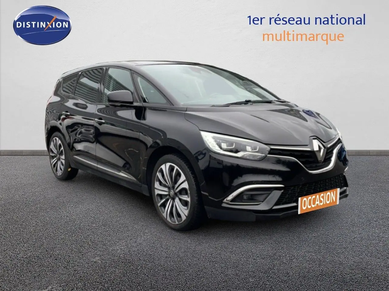 Renault Grand Scenic noir étoile métal en 3/4 avant droit, avec jantes alliage et calandre chromée visible.