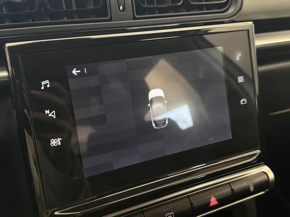 Écran tactile central affichant la vue aérienne d'une Citroën C3 blanche, intérieur noir moderne.